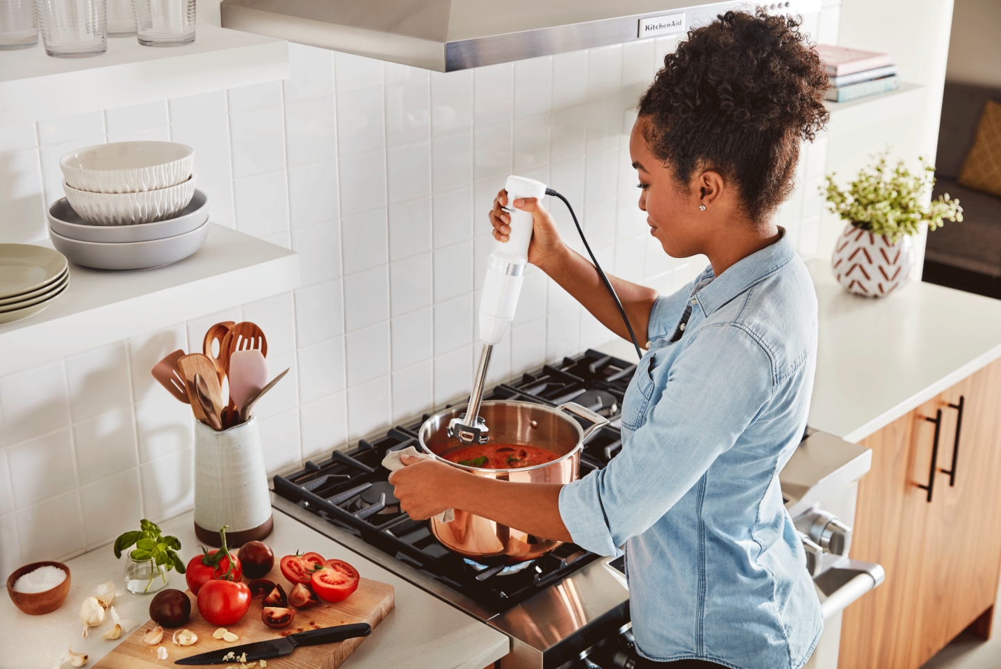 Woman using a hand blender in a pot on the stovetop