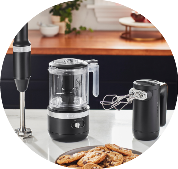 Onyx Black KitchenAid® Cordless Immersion Blender, Food Chopper, and Hand Mixer on white countertop.