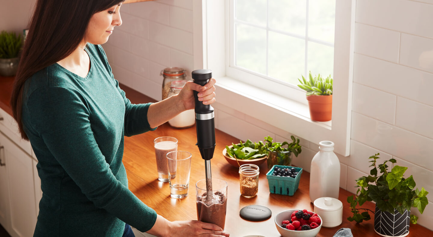 Person using a KitchenAid® cordless hand blender Person using a KitchenAid® cordless hand blender