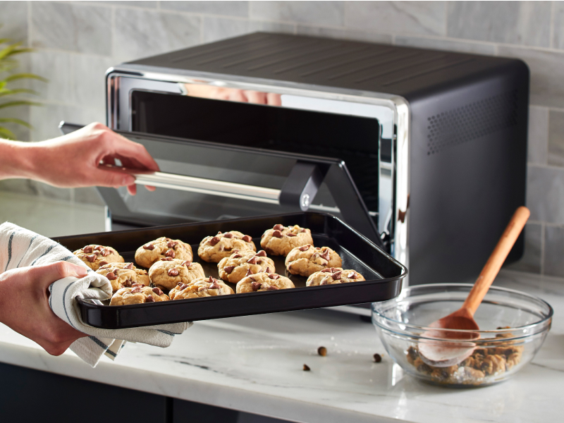 Tray of cookie dough going into a countertop oven Tray of cookie dough going into a countertop oven
