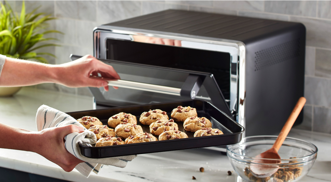 Tray of cookie dough going into a countertop oven Tray of cookie dough going into a countertop oven