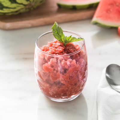 Shaved ice dessert garnished with fruit and mint