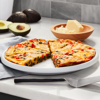 Plate of quiche on countertop with cheese and avocado