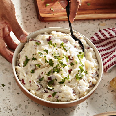Bowls of red-skinned mashed potatoes and roasted garlic