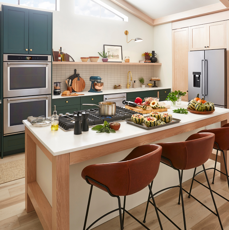 Kitchen island with cooktop and squash dish getting prepped for serving
