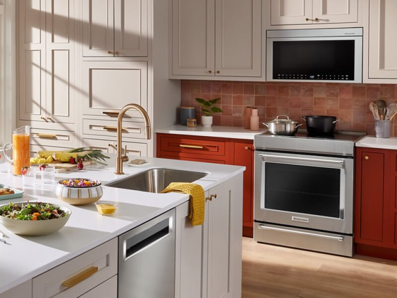 Stainless steel KitchenAid® electric range beneath a KitchenAid® over-the-range microwave