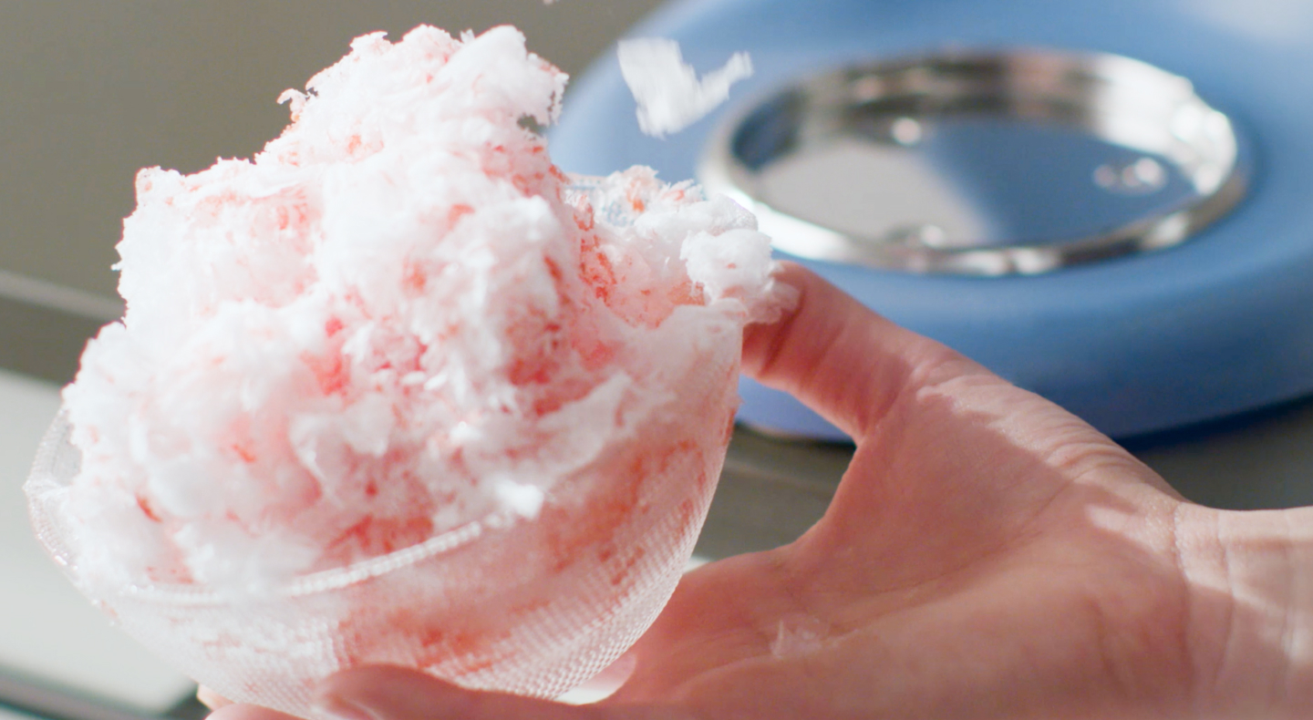 Fluffy shaved ice in front of a blue KitchenAid® stand mixer. Fluffy shaved ice in front of a blue KitchenAid® stand mixer.
