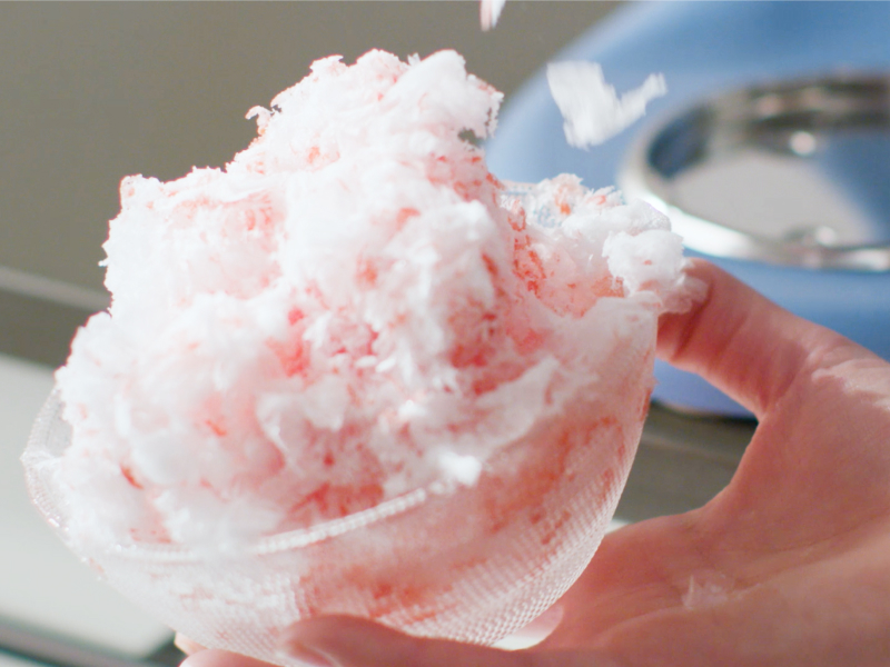 Fluffy shaved ice in front of a blue KitchenAid® stand mixer. Fluffy shaved ice in front of a blue KitchenAid® stand mixer.