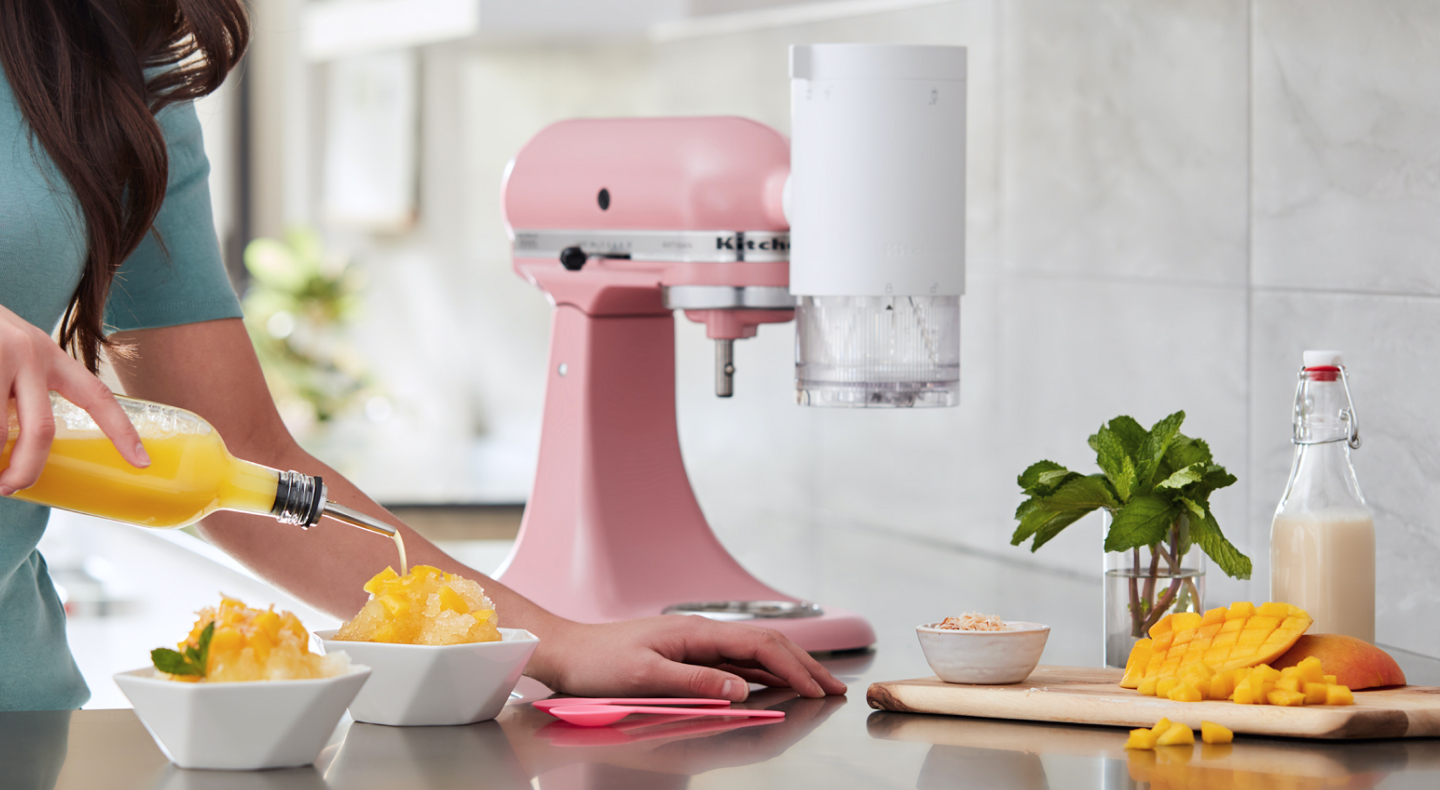 Person making mango flavored shaved ice with their KitchenAid® stand mixer. Person making mango flavored shaved ice with their KitchenAid® stand mixer.