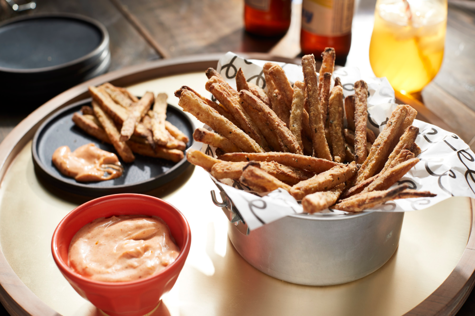 Homemade air-fried french fries and dipping sauce sitting on tray. Homemade air-fried french fries and dipping sauce sitting on tray.
