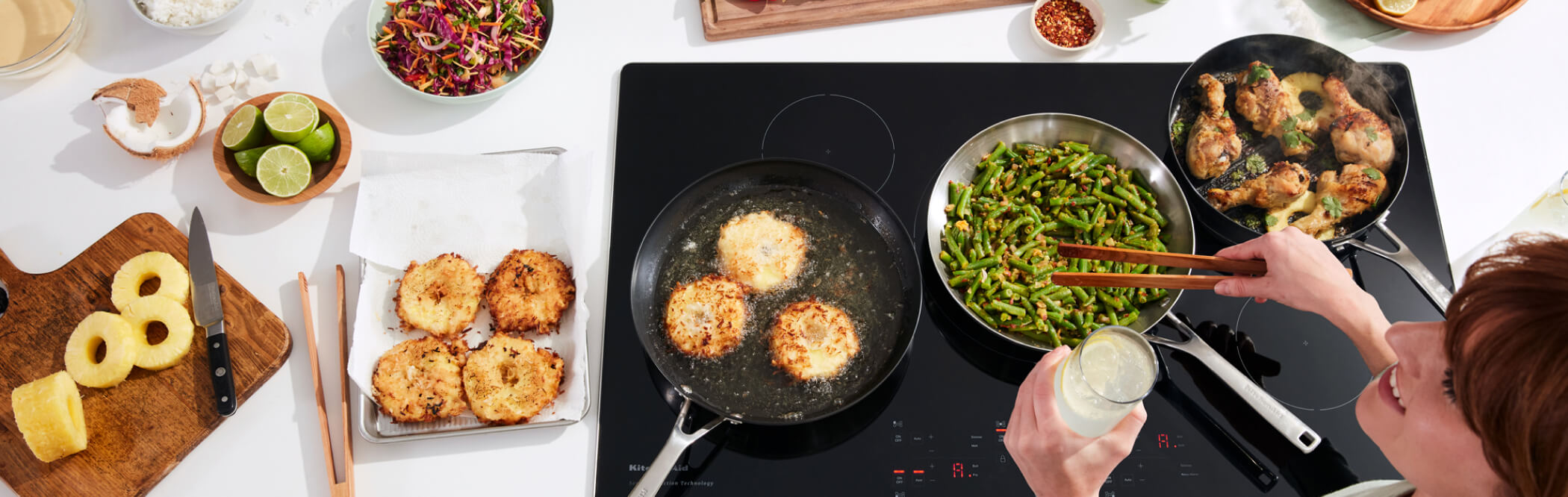 A person preparing various types of food on a KitchenAid® Cooktop