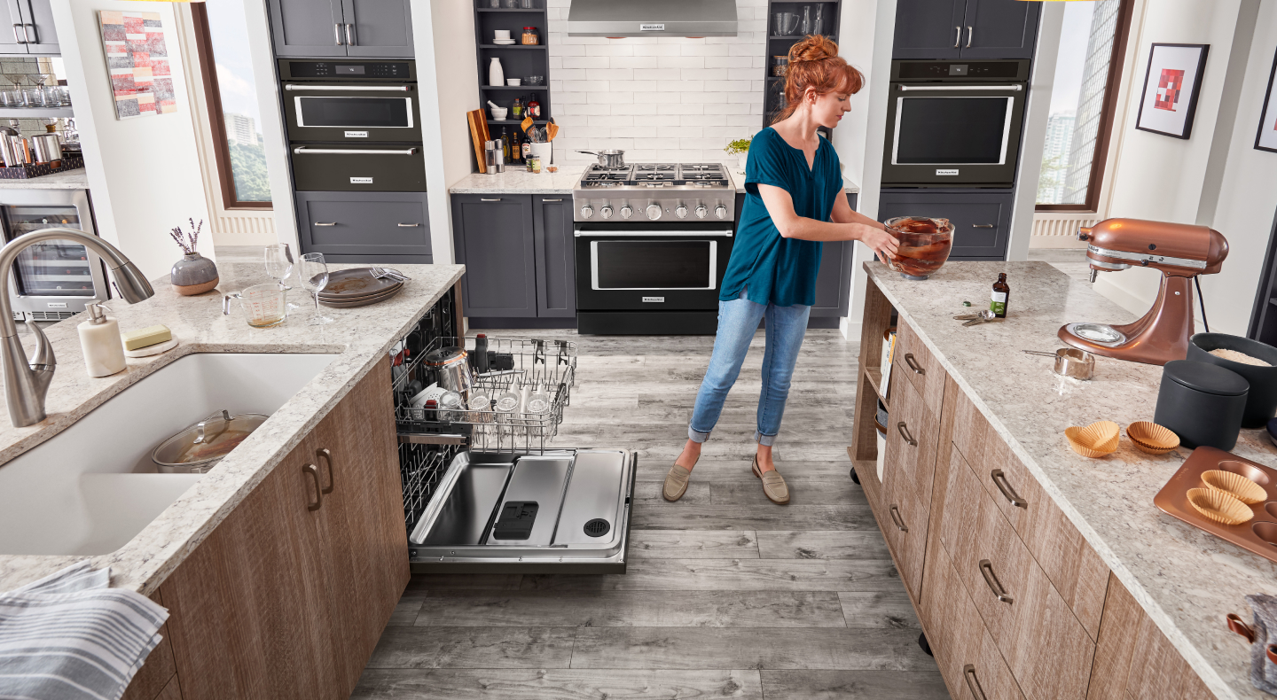 A KitchenAid® stand mixer on the counter with a person about to place the stand mixer bowl in the dishwasher. A KitchenAid® stand mixer on the counter with a person about to place the stand mixer bowl in the dishwasher.