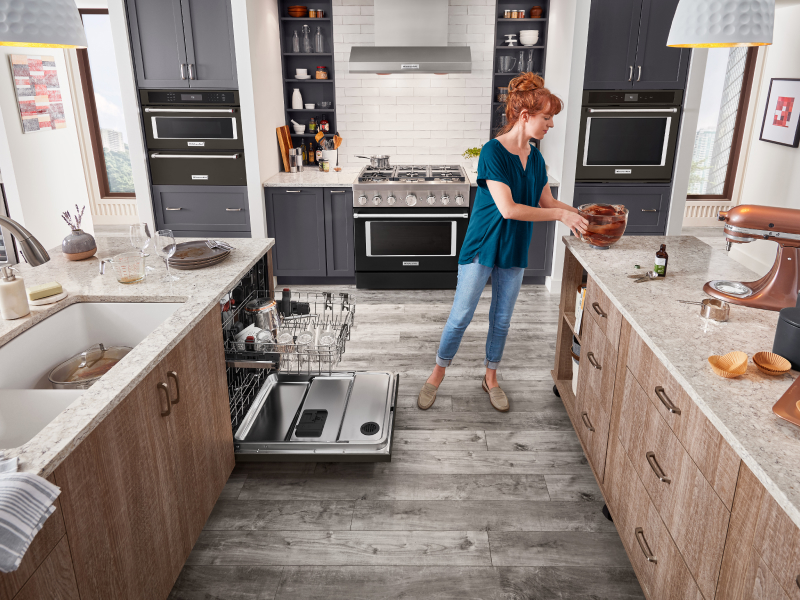 A KitchenAid® stand mixer on the counter with a person about to place the stand mixer bowl in the dishwasher. A KitchenAid® stand mixer on the counter with a person about to place the stand mixer bowl in the dishwasher.