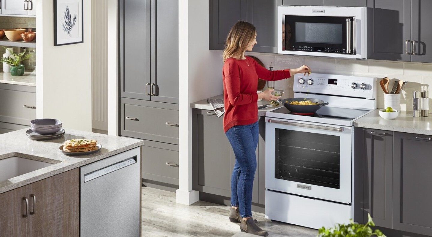 Person cooking on a white KitchenAid® stove