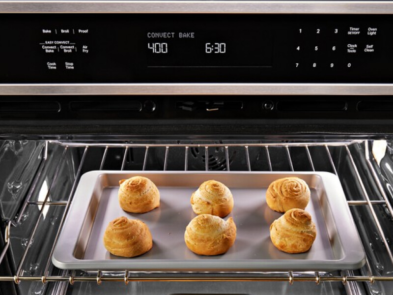 Close up image of bread rolls baking in an oven