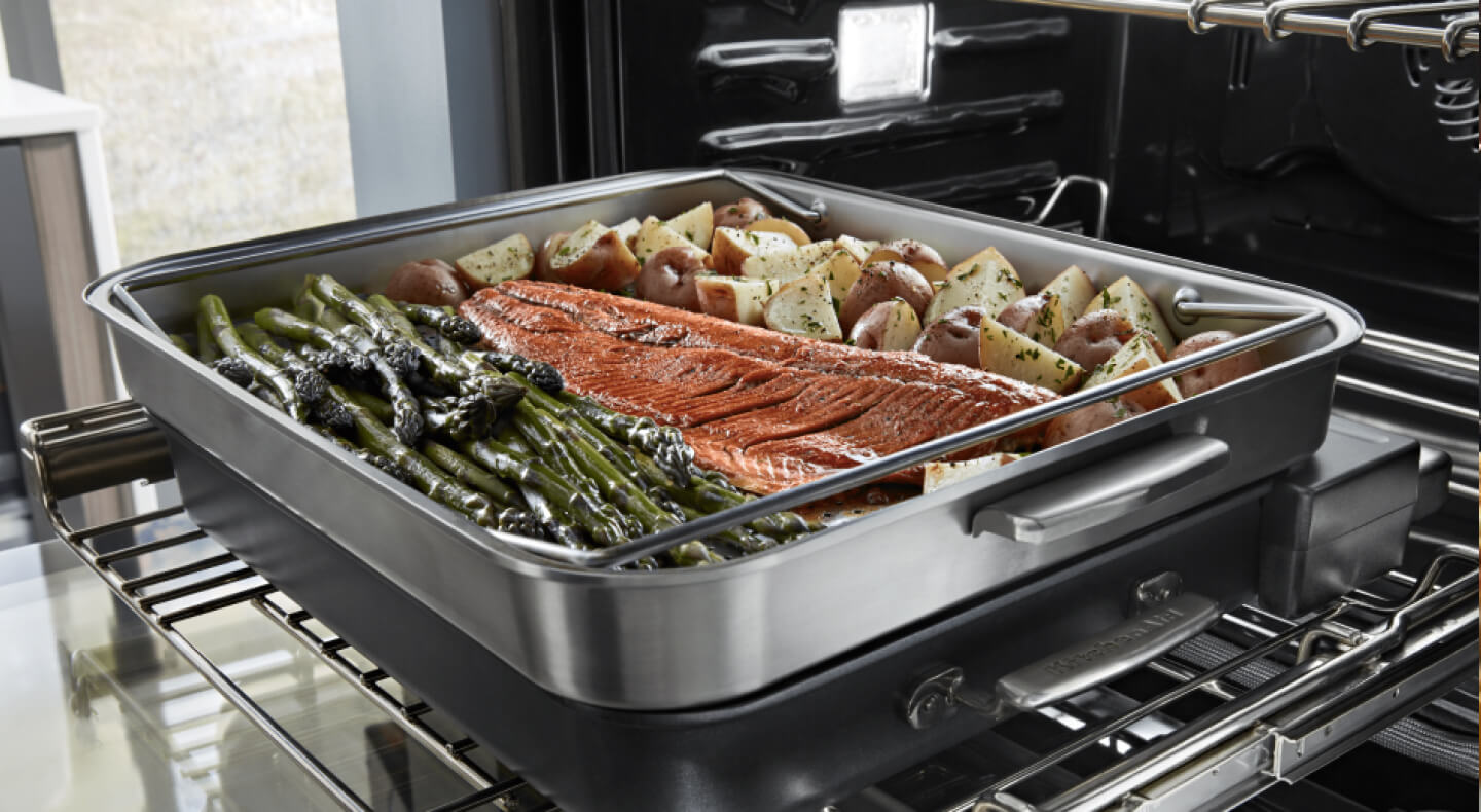 Salmon, asparagus and potatoes roasting in oven