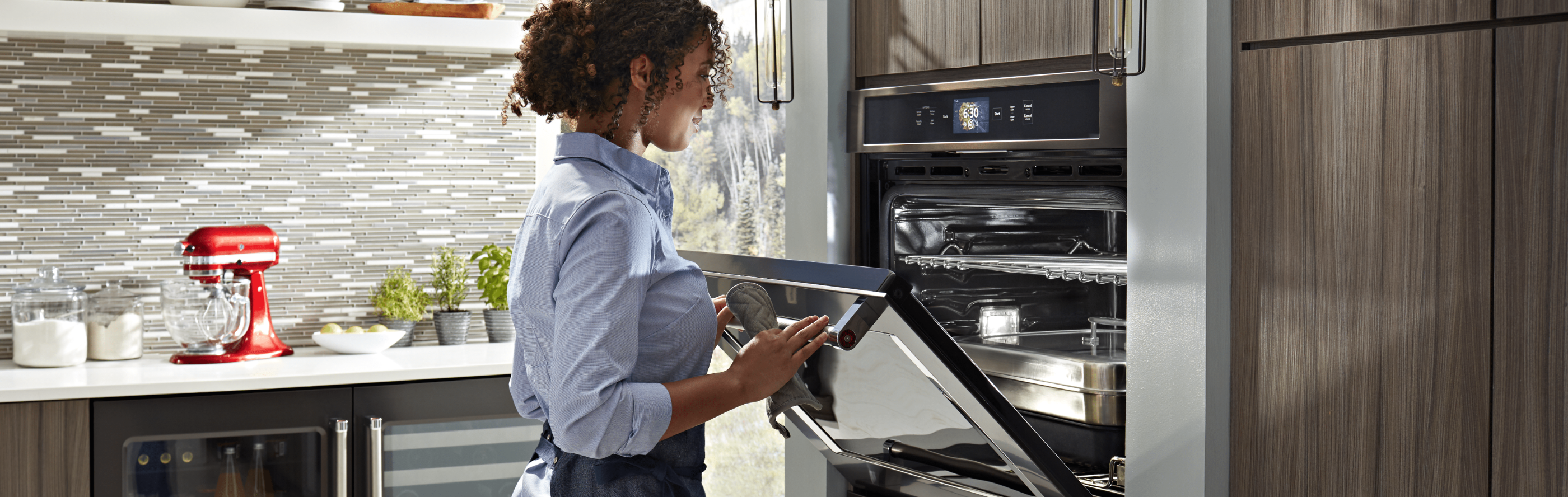 Woman opening an oven door and looking inside