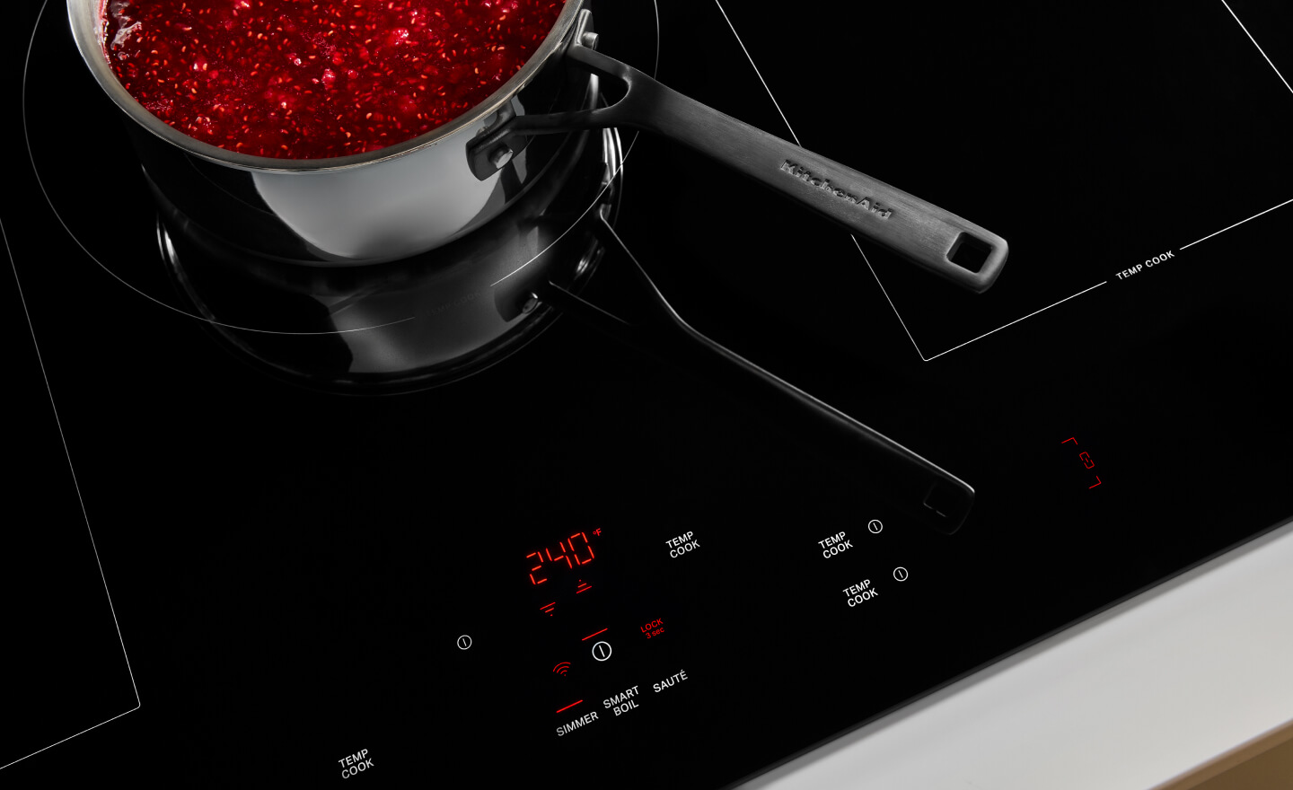 Food simmering in a saucepan on a glass cooktop
