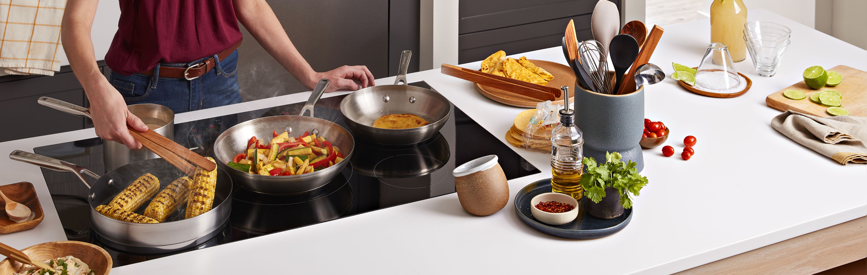 Multiple dishes cooking on a KitchenAid induction cooktop
