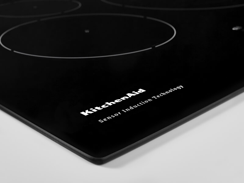 Close-up of KitchenAid brand writing on an induction cooktop