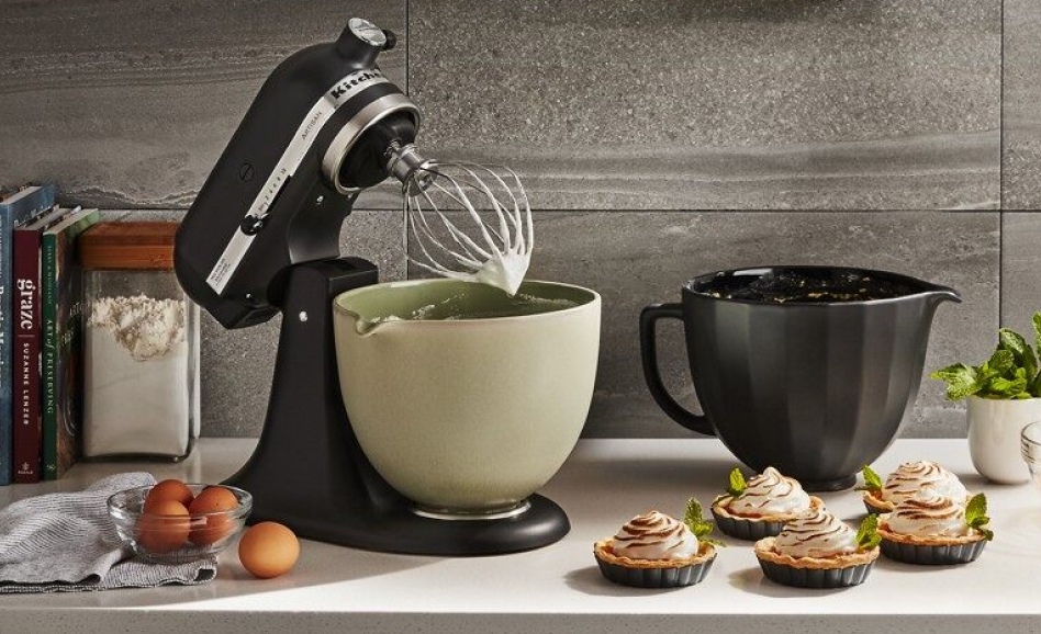 A black stand mixer on the counter with 4 ceramic mixing bowls. A black stand mixer on the counter with 4 ceramic mixing bowls.