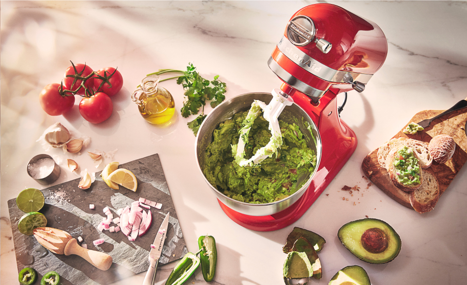 Red stand mixer from above with guacamole and ingredients Red stand mixer from above with guacamole and ingredients