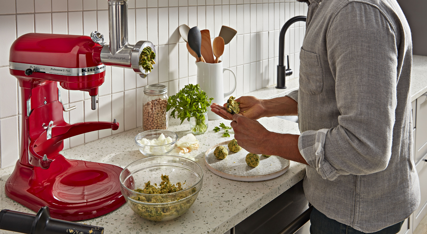 Person using metal food grinder attachment