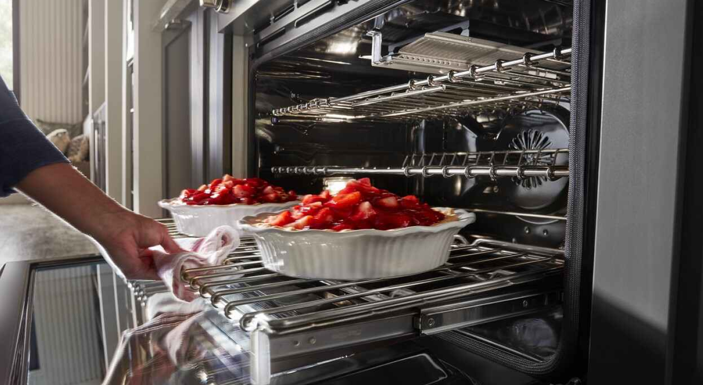 Person removing food from the oven Person removing food from the oven