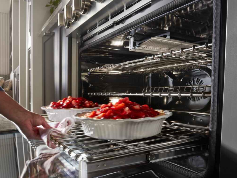 Person removing food from the oven Person removing food from the oven