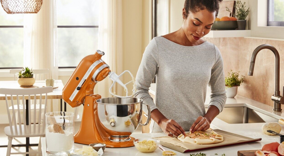 Woman making a galette next to a KitchenAid® stand mixer in Honey Woman making a galette next to a KitchenAid® stand mixer in Honey