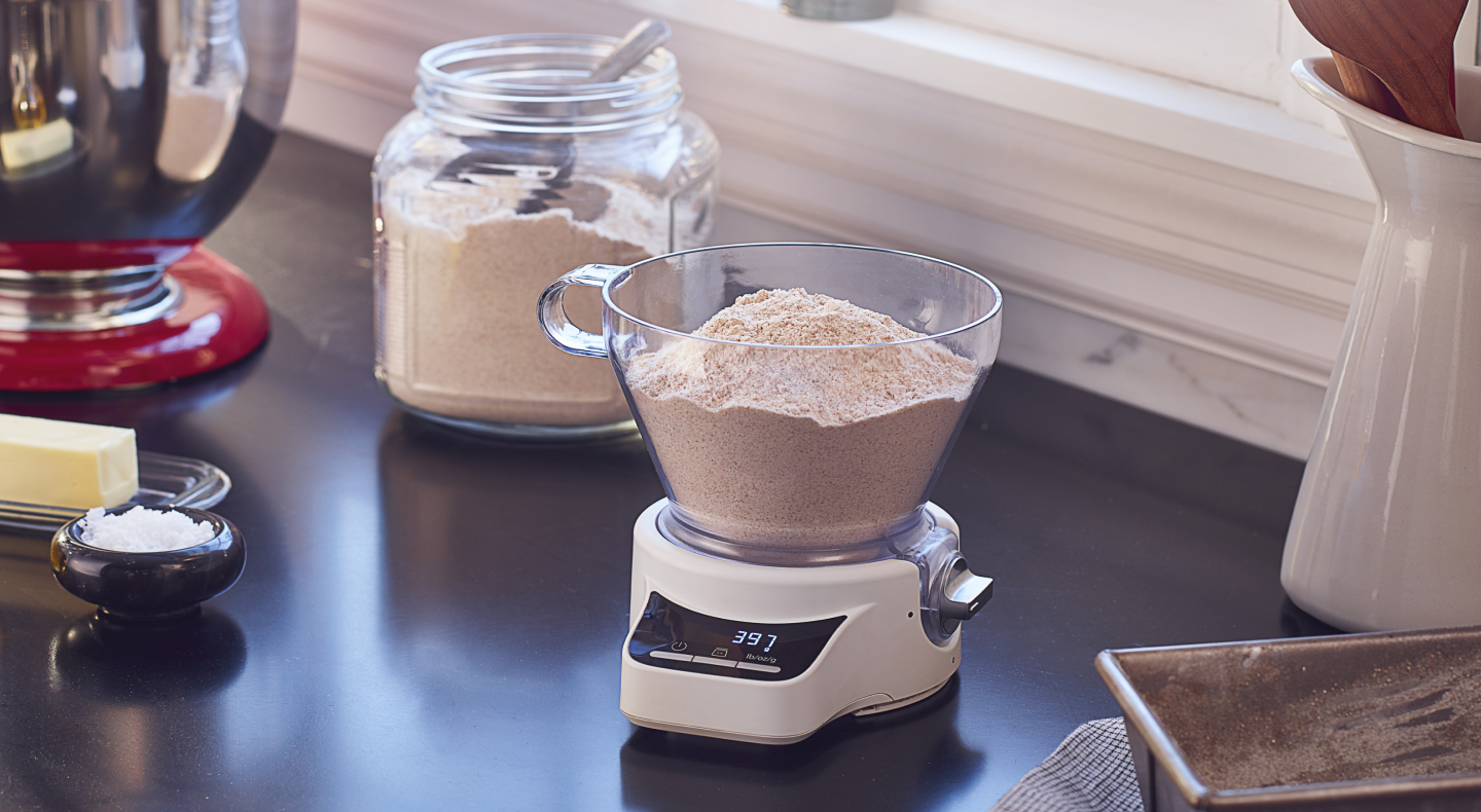 A container of flour being weighed. A container of flour being weighed.
