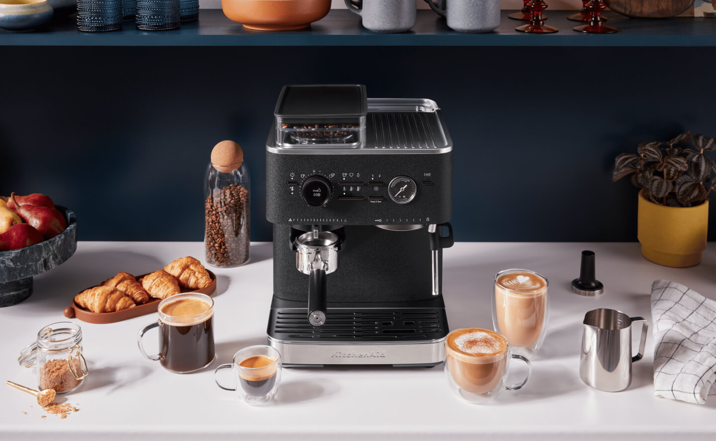 Black KitchenAid® Semi-Automatic Espresso Machine surrounded by espresso drinks Black KitchenAid® Semi-Automatic Espresso Machine surrounded by espresso drinks