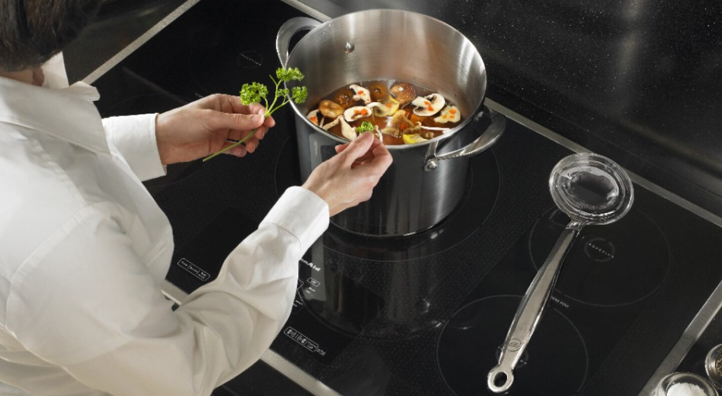 Person seasoning vegetable soup Person seasoning vegetable soup