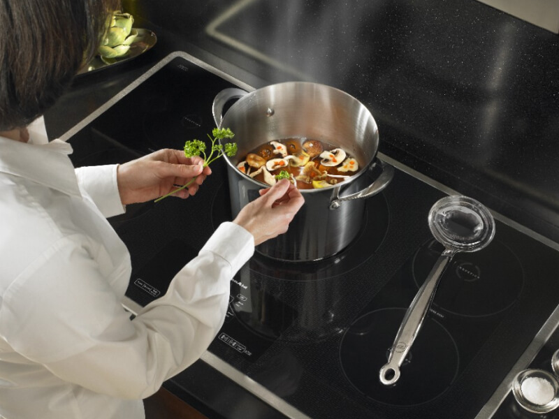 Person seasoning vegetable soup Person seasoning vegetable soup