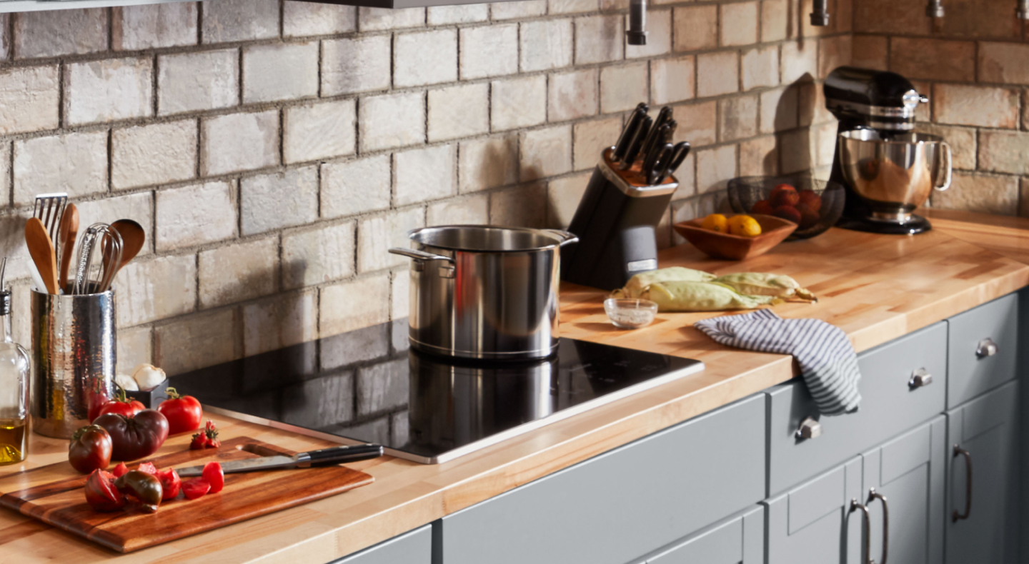 Pot resting on cooktop with sliced vegetables to the side Pot resting on cooktop with sliced vegetables to the side