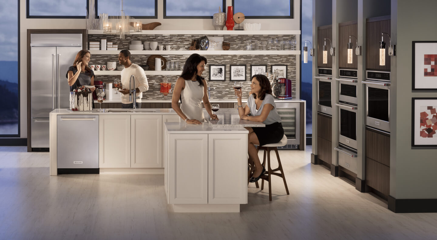 Four people sitting around a kitchen island Four people sitting around a kitchen island