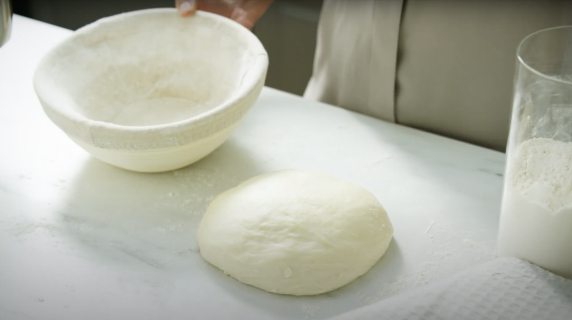 Rising dough and an empty proofing basket.