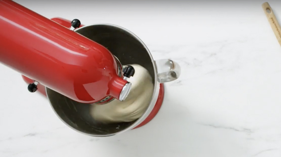Dough being stirred in a stand mixer bowl.