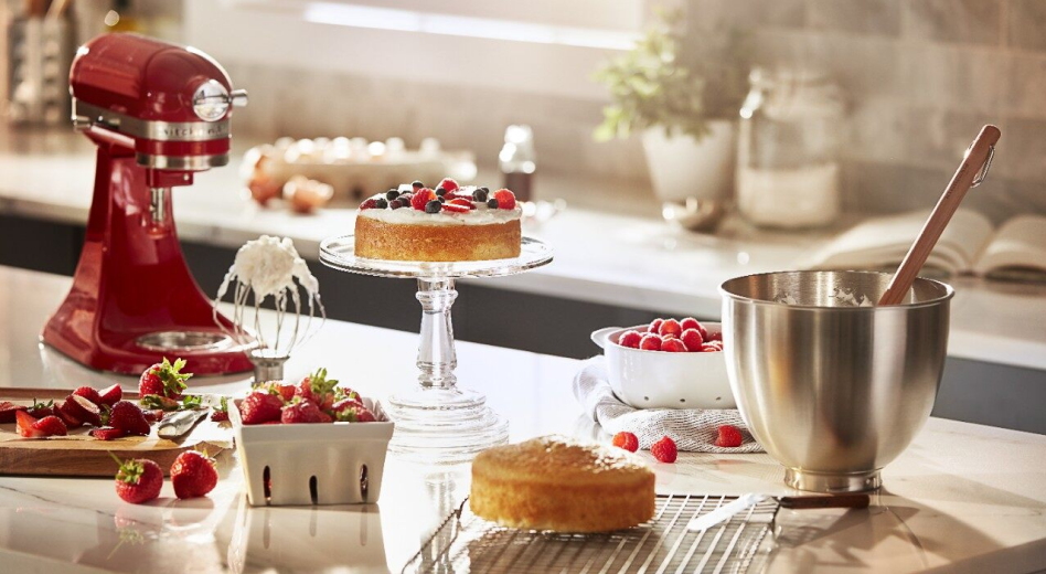 KitchenAid® stand mixer next to a cake, bowl of whipped cream and carton of berries. KitchenAid® stand mixer next to a cake, bowl of whipped cream and carton of berries.