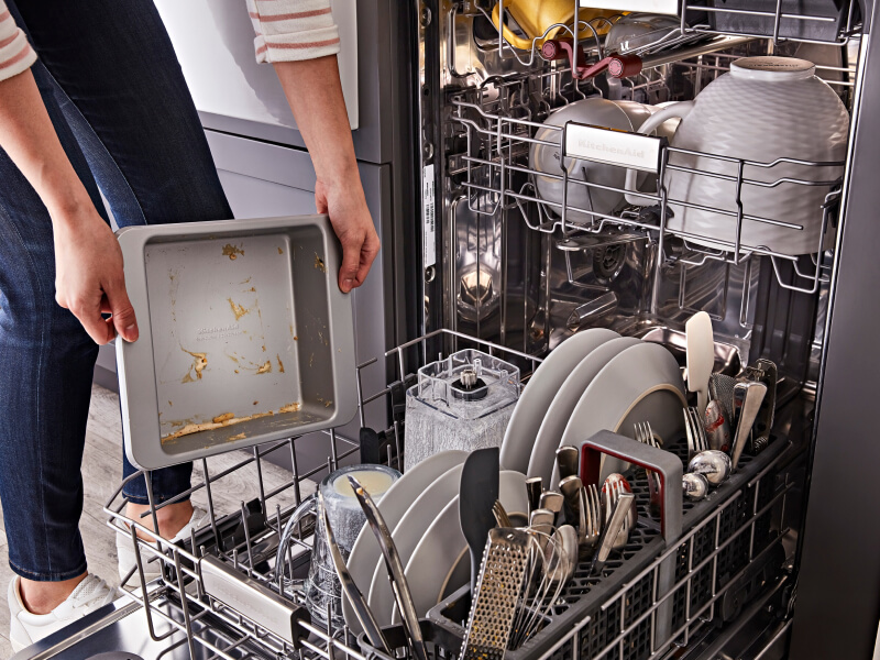 Person loading dirty dishes into a dishwasher