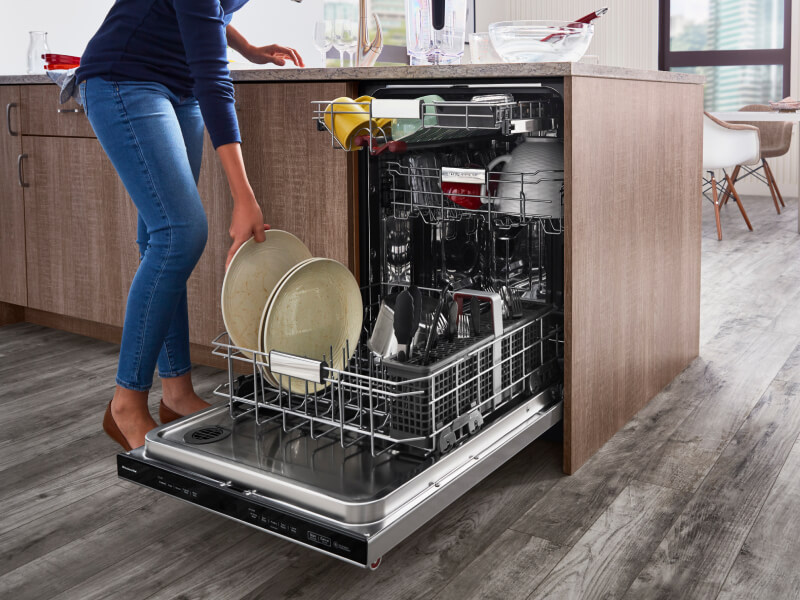 Woman loading dishes into a dishwasher