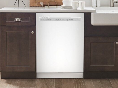 Stainless steel front control dishwasher next to dark cabinets