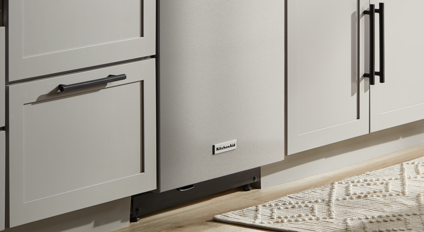 Stainless steel KitchenAid® dishwasher in between light grey cabinets Stainless steel KitchenAid® dishwasher in between light grey cabinets