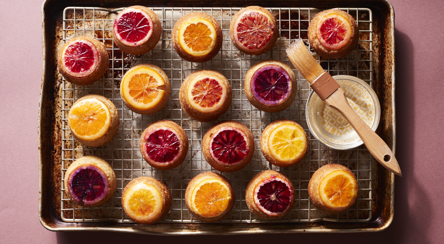 Citrus topped baked goods on cooking rack above cookie sheet Citrus topped baked goods on cooking rack above cookie sheet