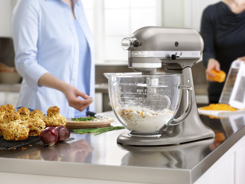 Ingredients mixing in the glass bowl of a silver stand mixer