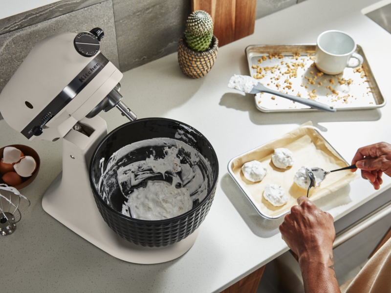 Person putting dough onto prepared baking dish