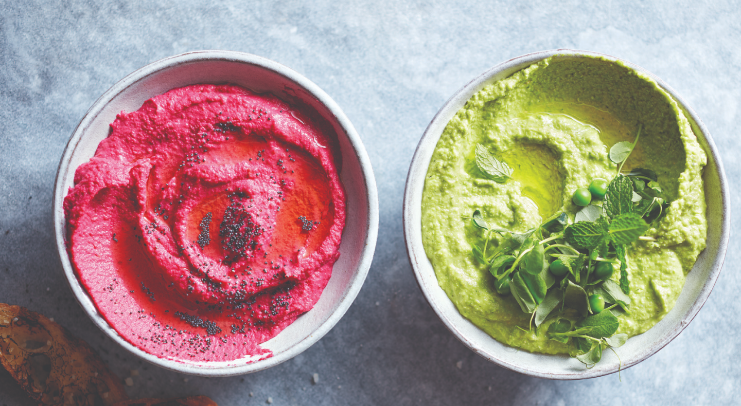 Pink and green hummus topped with fresh herbs Pink and green hummus topped with fresh herbs