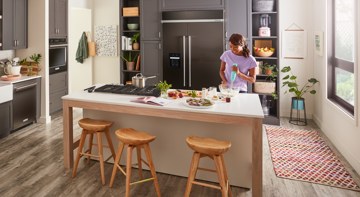 A woman using an immersion blender in a kitchen A woman using an immersion blender in a kitchen