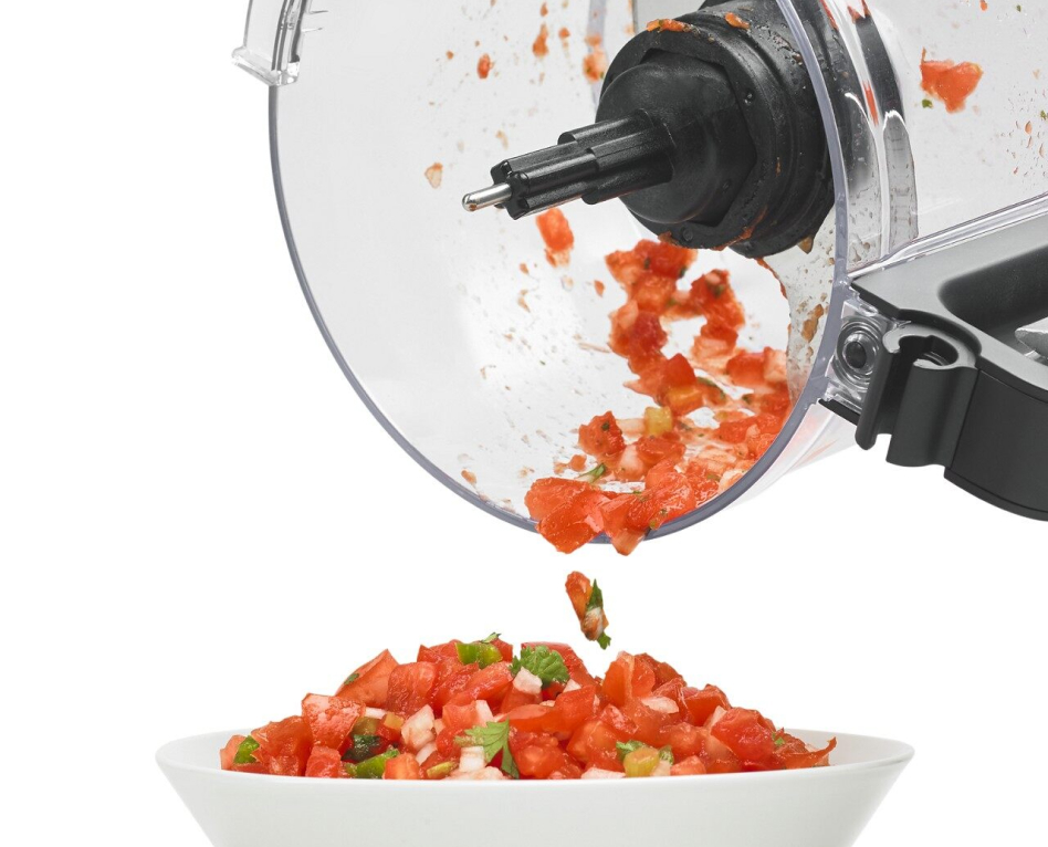 Salsa being transferred from food processor work bowl to a serving bowl Salsa being transferred from food processor work bowl to a serving bowl