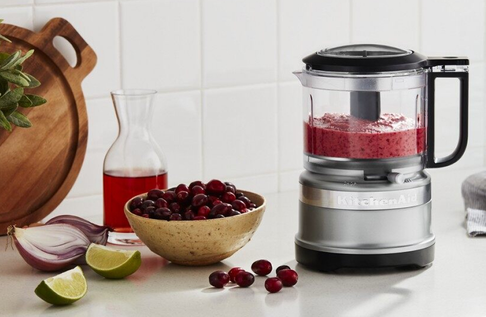 Food processor filled with a fruit purée on a counter Food processor filled with a fruit purée on a counter